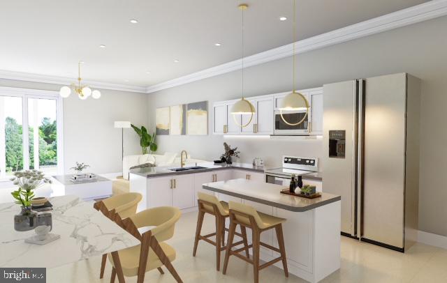 kitchen featuring an inviting chandelier, stainless steel appliances, pendant lighting, white cabinets, and sink