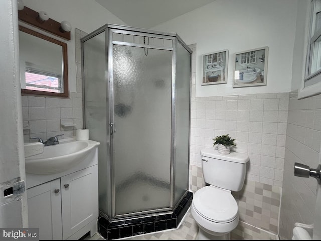 bathroom with tile flooring, tile walls, oversized vanity, an enclosed shower, and toilet