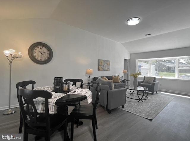 dining area featuring dark wood-type flooring and lofted ceiling