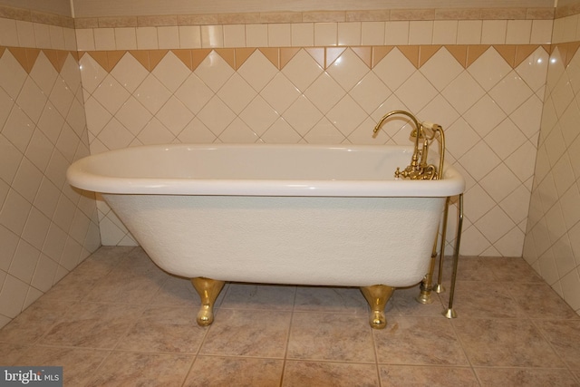 bathroom featuring a bathing tub, tile walls, and tile patterned floors