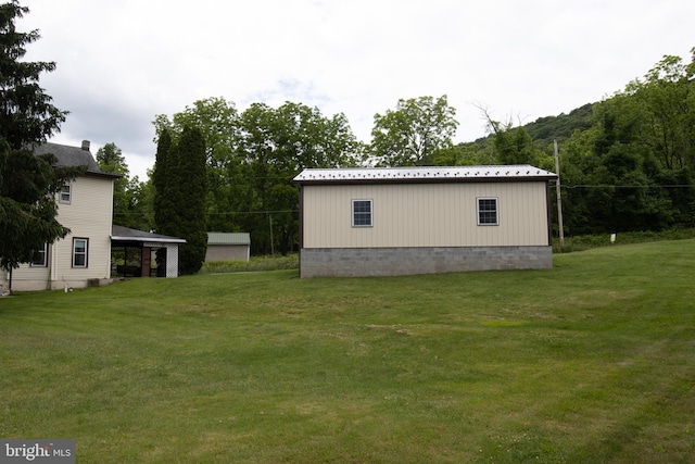 view of side of property featuring a lawn and a carport