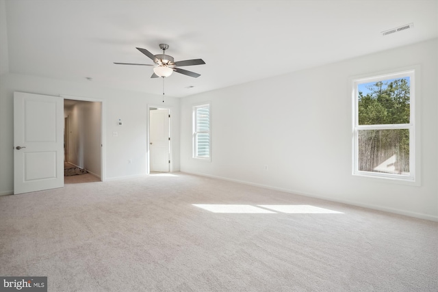 carpeted spare room featuring ceiling fan