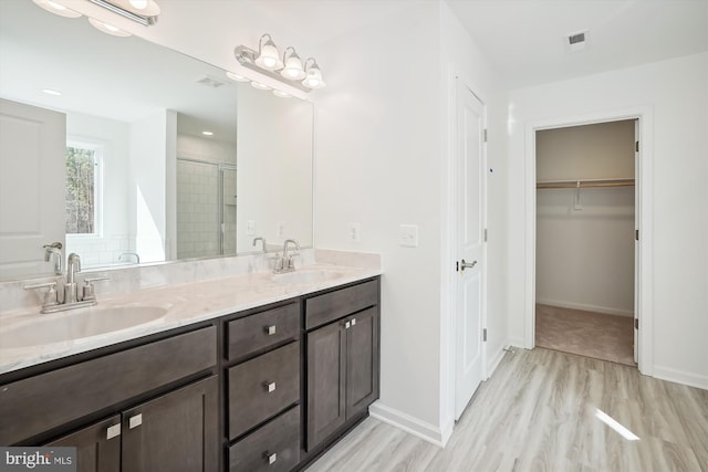 bathroom with oversized vanity, hardwood / wood-style flooring, and double sink