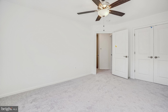 unfurnished bedroom with light colored carpet, ceiling fan, and a closet