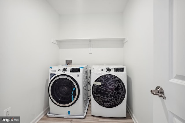 laundry room with hookup for a washing machine, washing machine and dryer, and light wood-type flooring