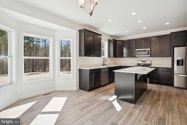 kitchen featuring plenty of natural light, a center island, stainless steel appliances, and light hardwood / wood-style floors