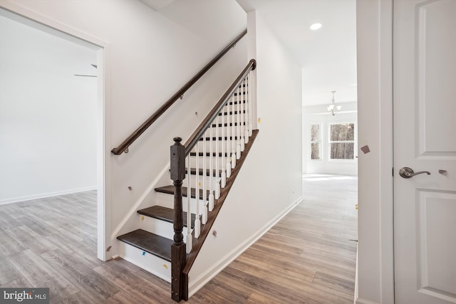 stairway with light hardwood / wood-style floors