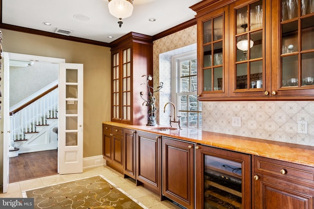 bar with beverage cooler, crown molding, light hardwood / wood-style flooring, sink, and tasteful backsplash