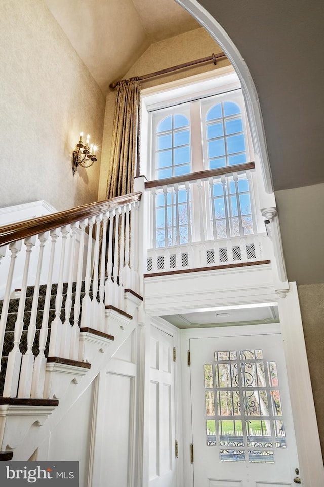 stairway with plenty of natural light and a high ceiling