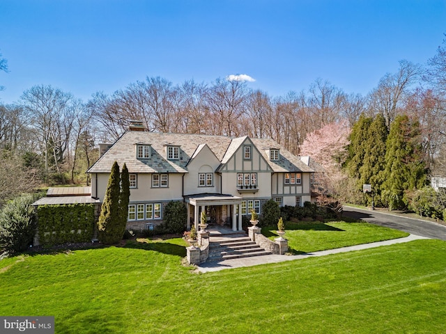 tudor-style house with a front lawn