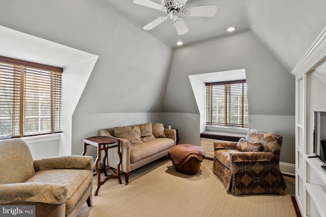 living room with a wealth of natural light, ceiling fan, and vaulted ceiling