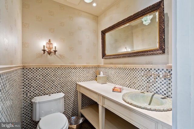 bathroom featuring backsplash, vanity, toilet, and tile walls