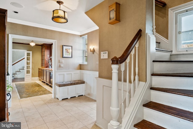 stairway featuring ornamental molding and light tile floors