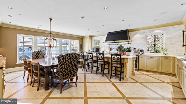 dining space featuring plenty of natural light, a notable chandelier, light tile floors, and ornamental molding