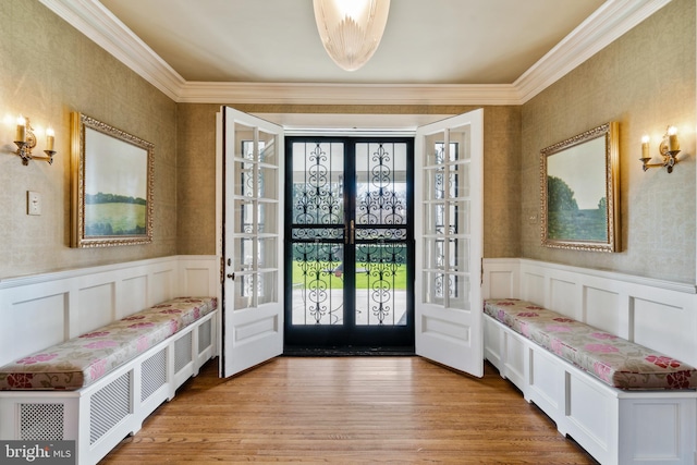 interior space with ornamental molding, light hardwood / wood-style flooring, and french doors