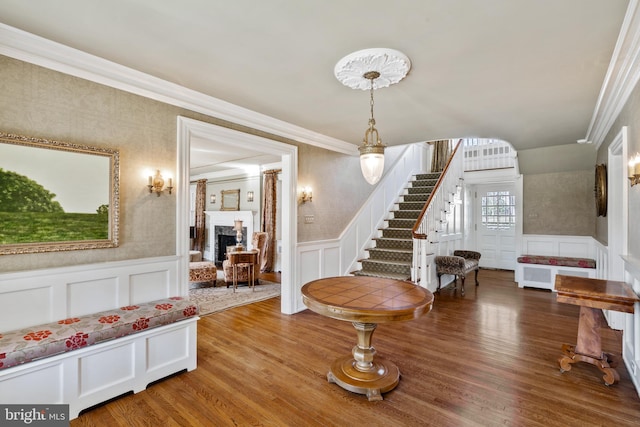 foyer entrance with ornamental molding and wood-type flooring