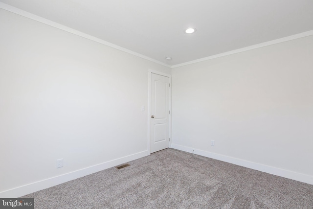 unfurnished room with ornamental molding and carpet