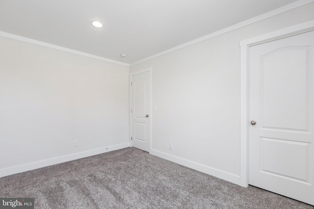 carpeted empty room featuring crown molding