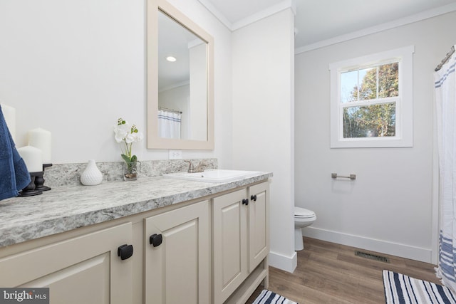 bathroom featuring vanity, toilet, hardwood / wood-style flooring, and crown molding