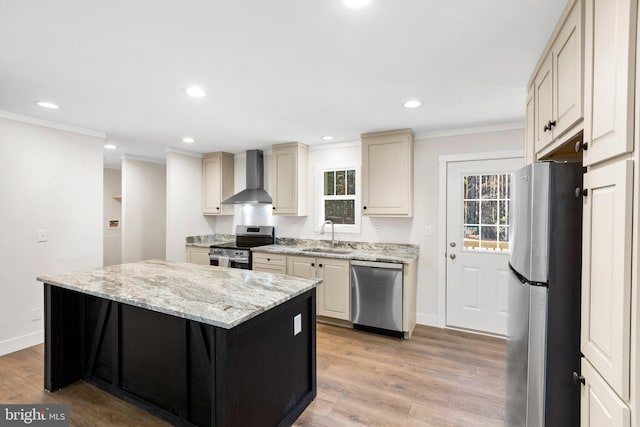 kitchen with wall chimney exhaust hood, appliances with stainless steel finishes, a wealth of natural light, and light wood-type flooring