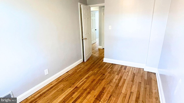 unfurnished room with wood-type flooring