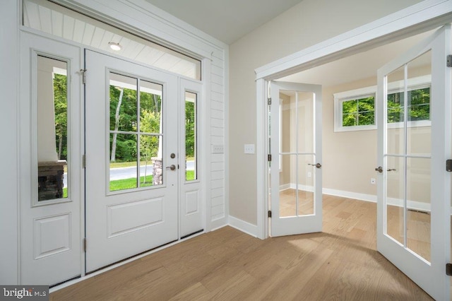 entryway with a healthy amount of sunlight, light hardwood / wood-style flooring, and french doors