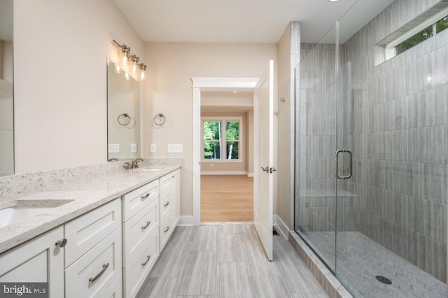 bathroom featuring a shower with shower door, tile flooring, and double sink vanity