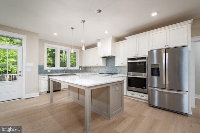 kitchen featuring light hardwood / wood-style floors, tasteful backsplash, a kitchen island, and stainless steel appliances