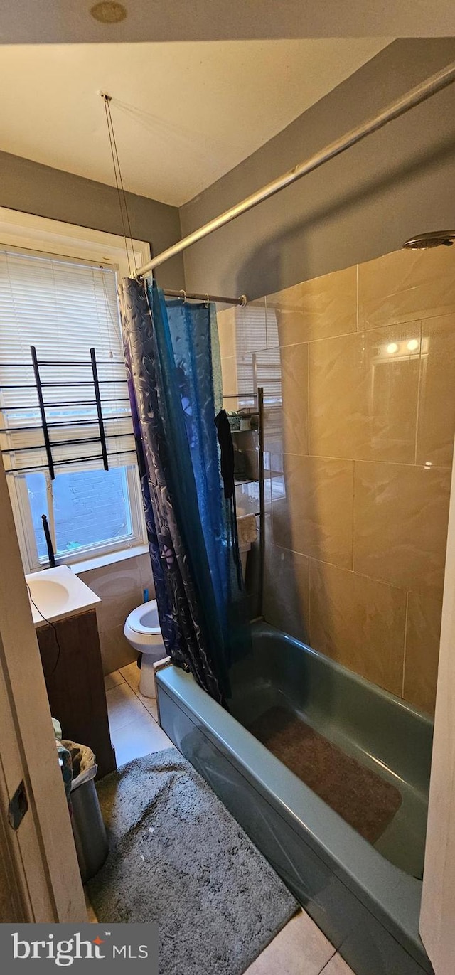 bathroom featuring tile patterned floors, shower / bath combo with shower curtain, and toilet