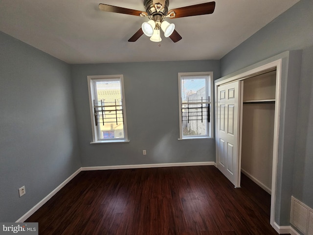 unfurnished bedroom with a closet, ceiling fan, and dark wood-type flooring