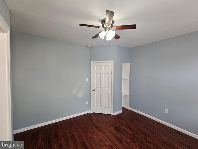 empty room with ceiling fan and dark hardwood / wood-style flooring