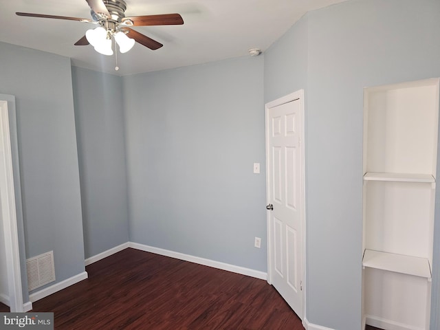 empty room with ceiling fan and dark hardwood / wood-style flooring