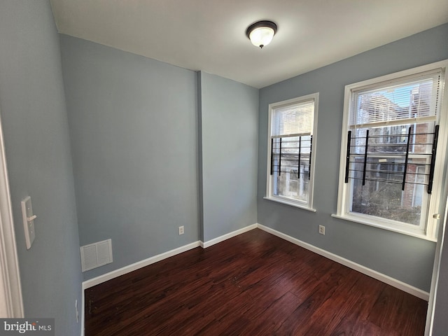 spare room with dark hardwood / wood-style flooring