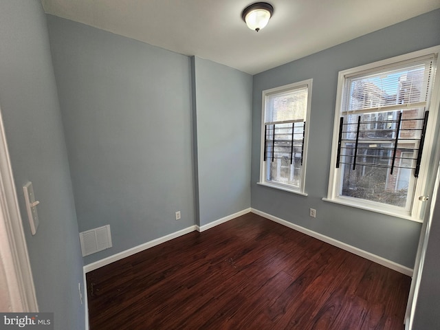 empty room with dark hardwood / wood-style flooring