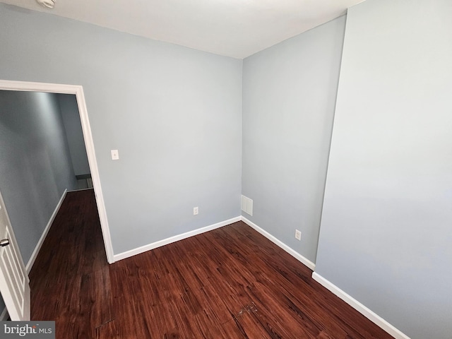 empty room with dark hardwood / wood-style flooring