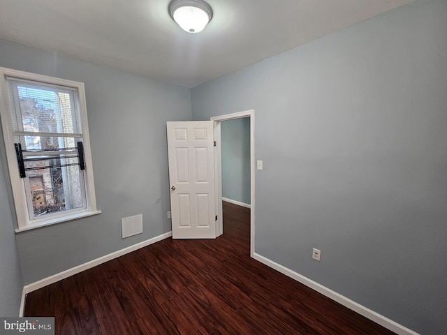 spare room with dark wood-type flooring