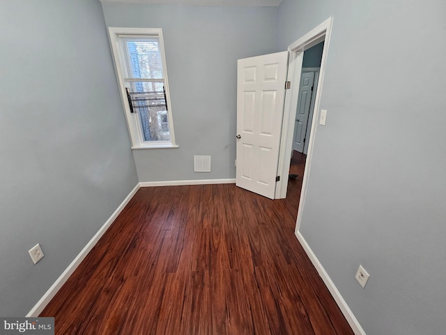 unfurnished room with dark hardwood / wood-style flooring