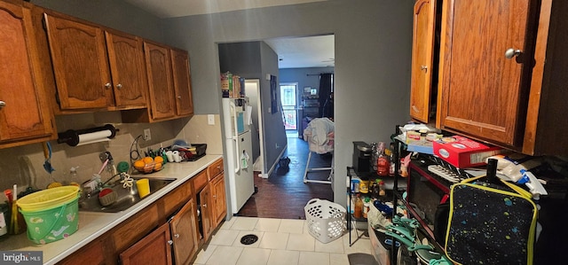 kitchen with white refrigerator, light hardwood / wood-style flooring, and sink