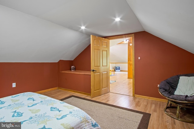 bedroom featuring light hardwood / wood-style floors and vaulted ceiling