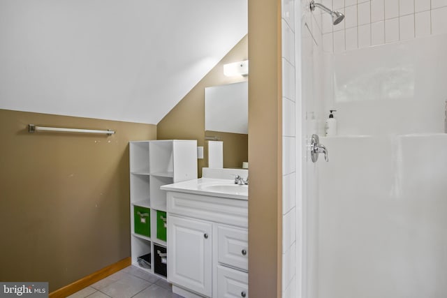 bathroom with a shower, oversized vanity, vaulted ceiling, and tile flooring