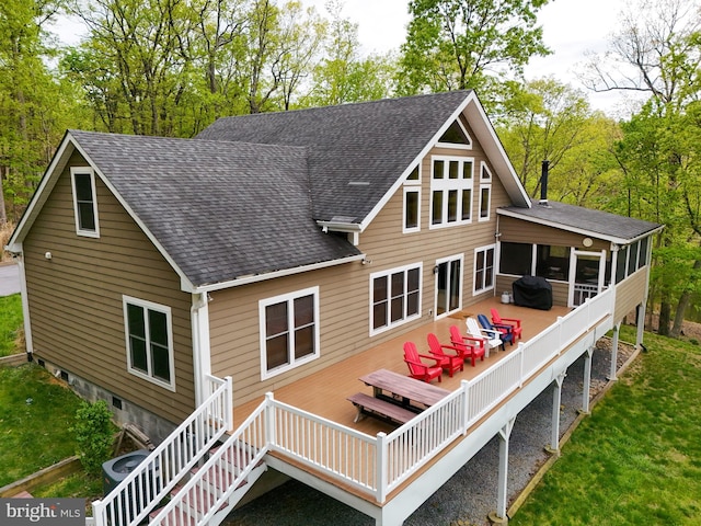 rear view of house featuring a deck and a sunroom