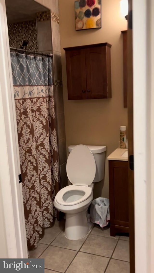 bathroom featuring toilet, curtained shower, vanity, and tile patterned flooring