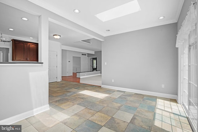 tiled spare room featuring a skylight and ornamental molding