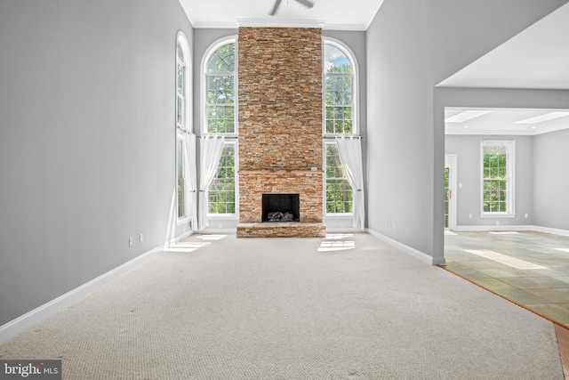 unfurnished living room with a fireplace, a wealth of natural light, carpet floors, and ornamental molding