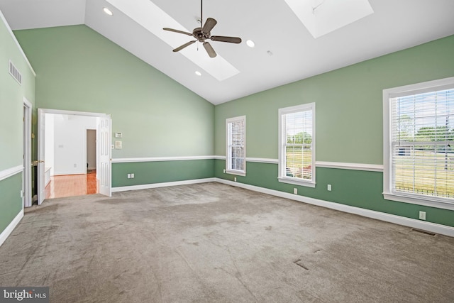 unfurnished room featuring a skylight, ceiling fan, and carpet