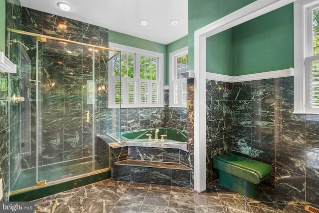 bathroom featuring tile walls, tile floors, and separate shower and tub