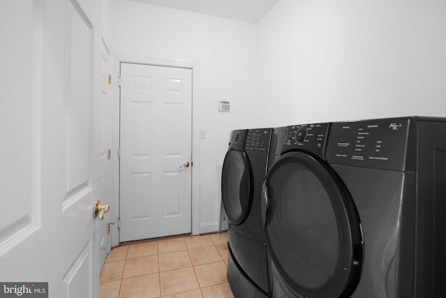 washroom featuring independent washer and dryer and light tile floors