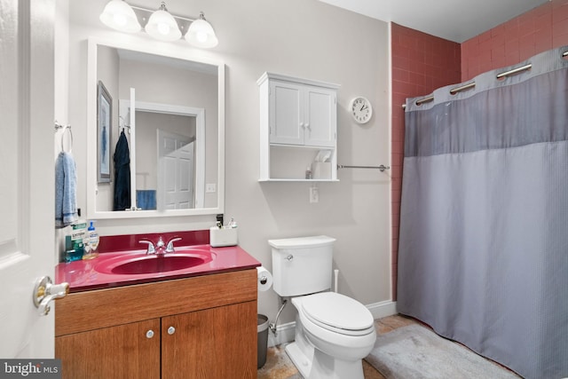 bathroom featuring toilet, tile flooring, and vanity