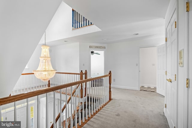 hall with an inviting chandelier and carpet