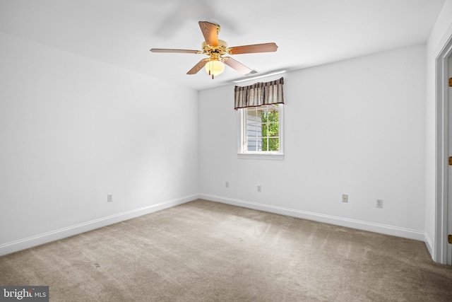 carpeted spare room featuring ceiling fan